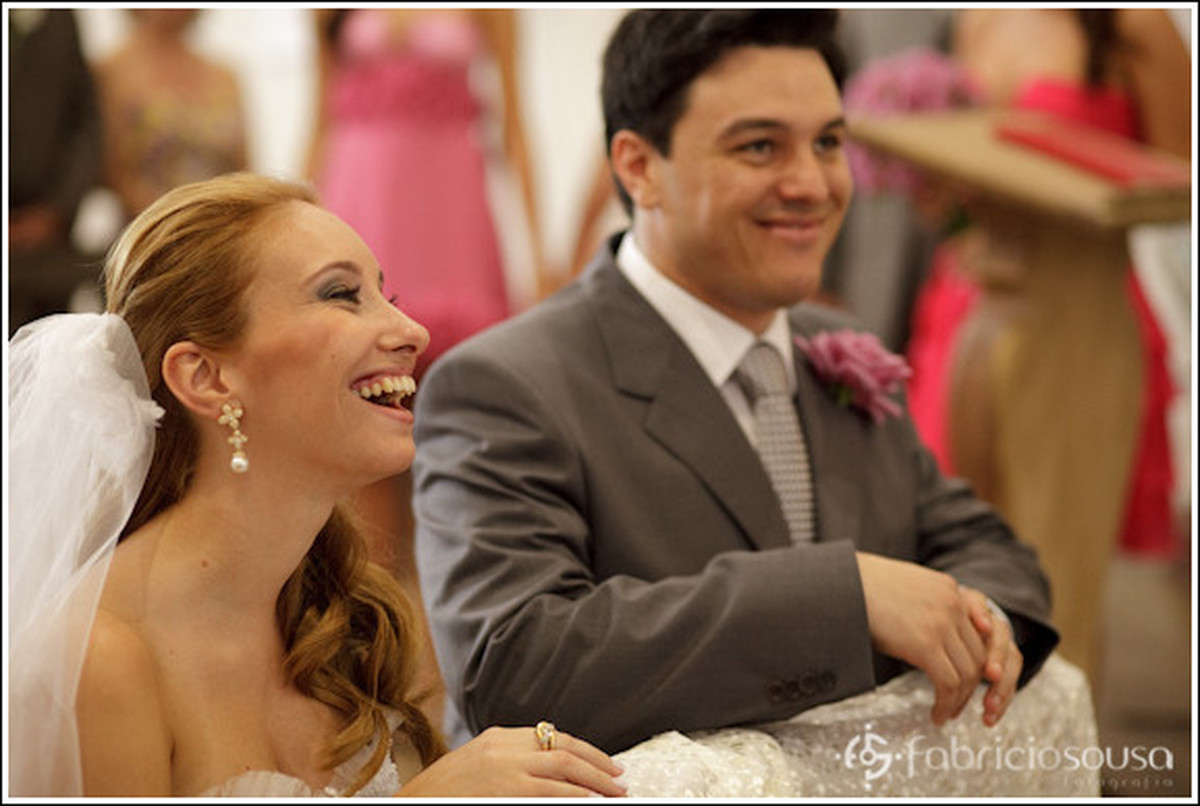 noivos sorrindo ajoelhados no altar
