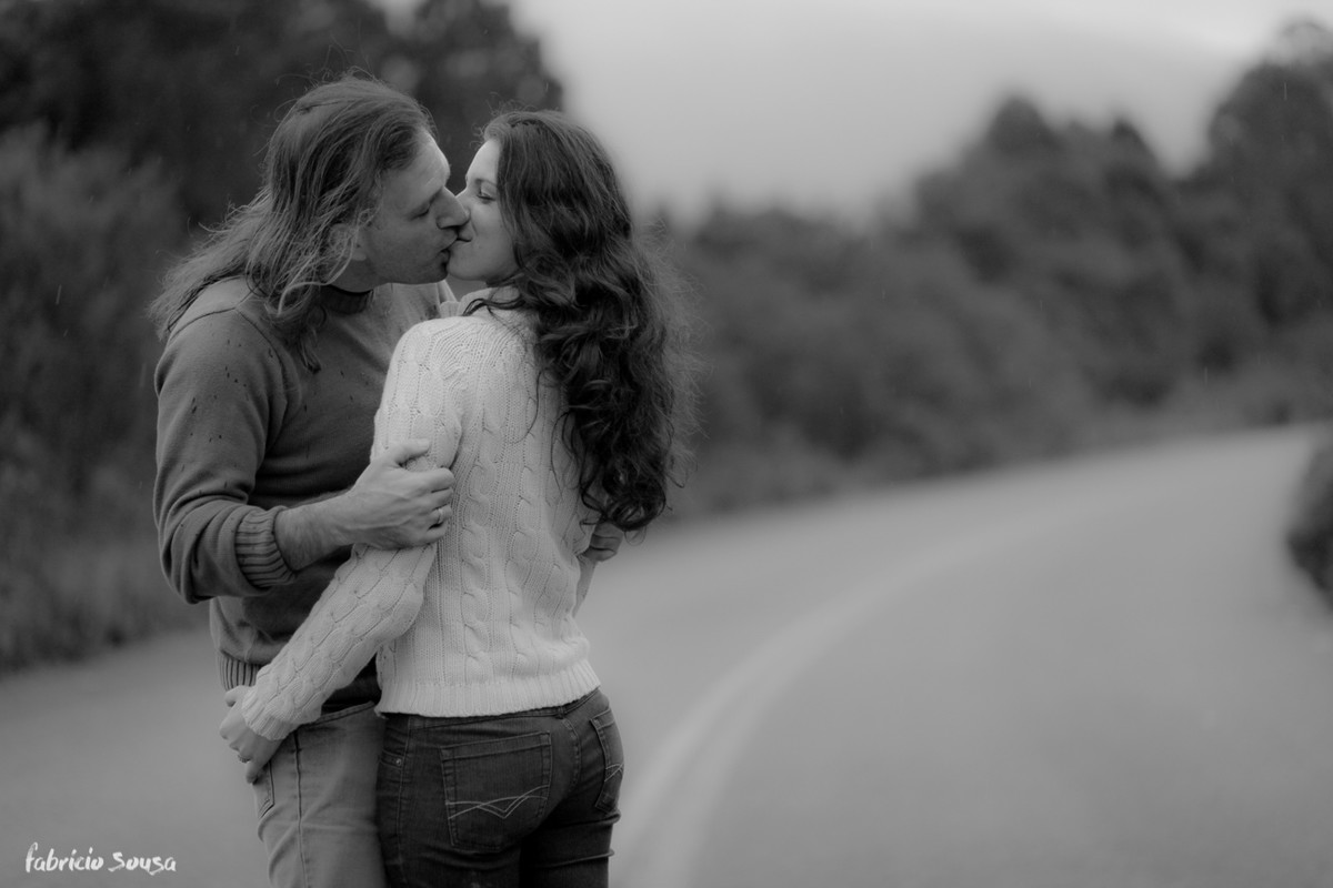 Casal de namorados abraçados se beijando no meio da estrada