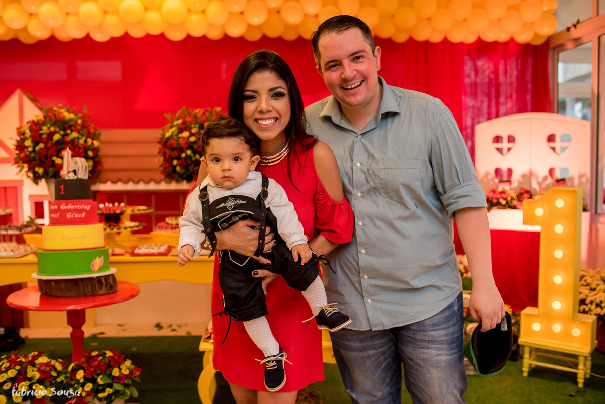 família posando em frente ao bolo no começo do aniversário