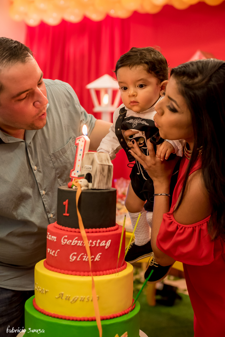 papai e mamãe apagando as velinhas do aniversario infantil