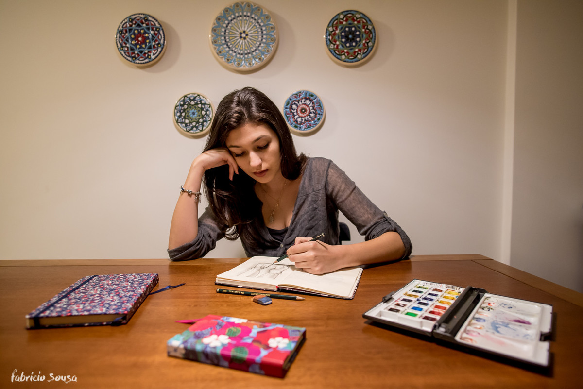 Carol desenhando no seu apartamento