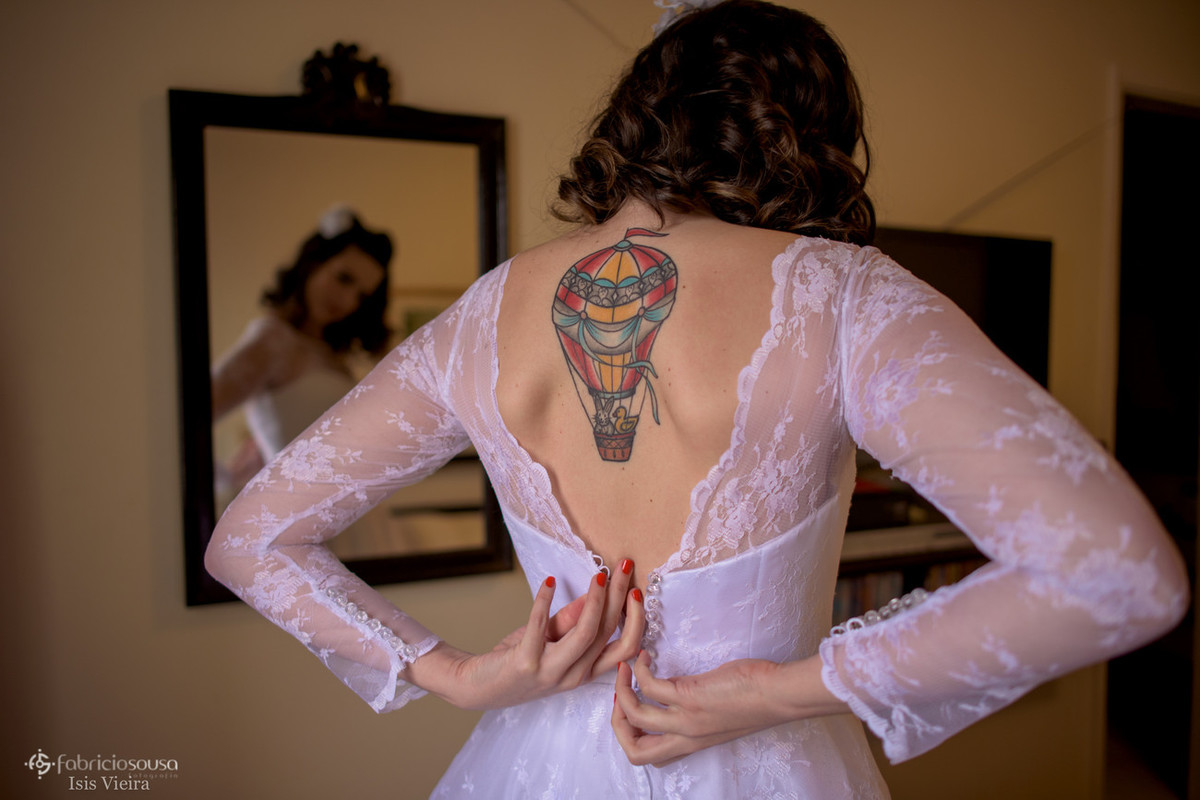 a noiva abotoando o vestido boudoir