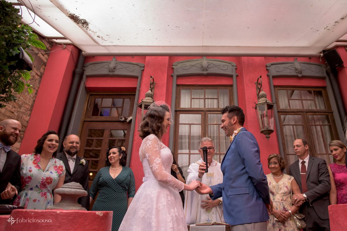Casal de noivos atentos às palavras do padre