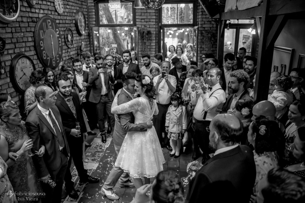 Recem casados dançam ao redor dos convidados preto e branco