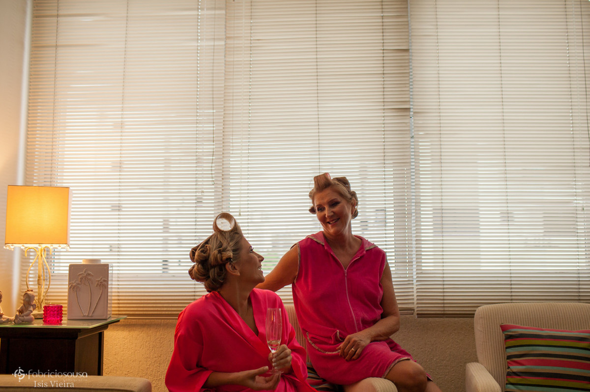 Filha e mãe conversam em casa com bobs nos cabelos