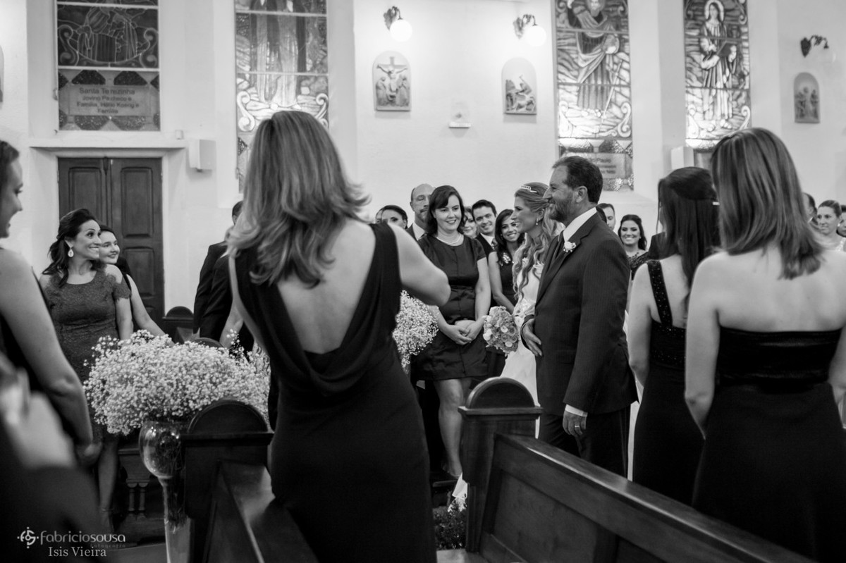 Convidados presentes na igreja registram a entrada da noiva