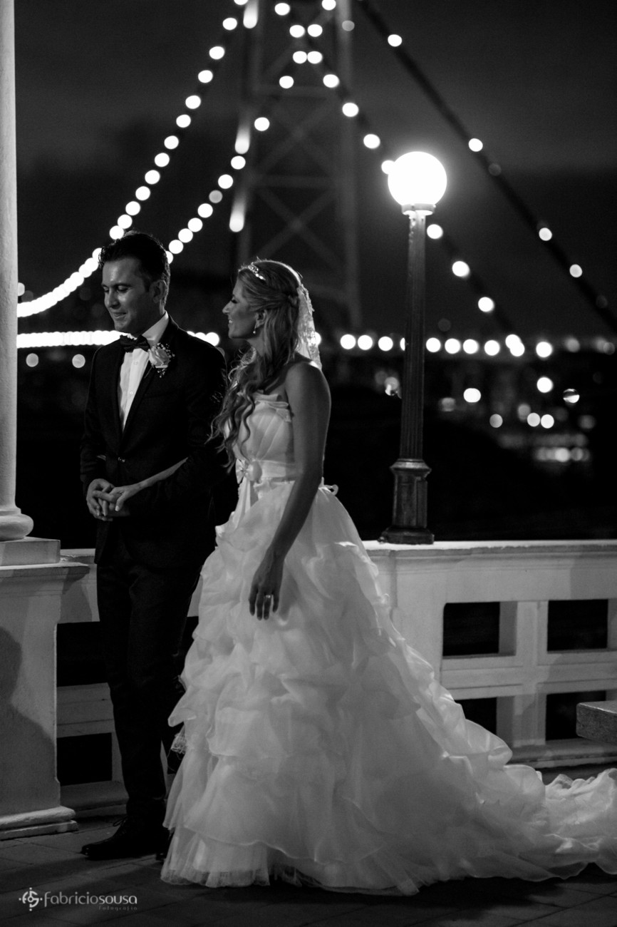 Casal caminha com ponte ao fundo