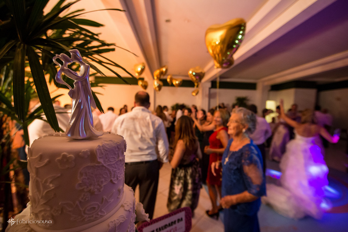 Foco no bolo e balões em formato de coração na festa