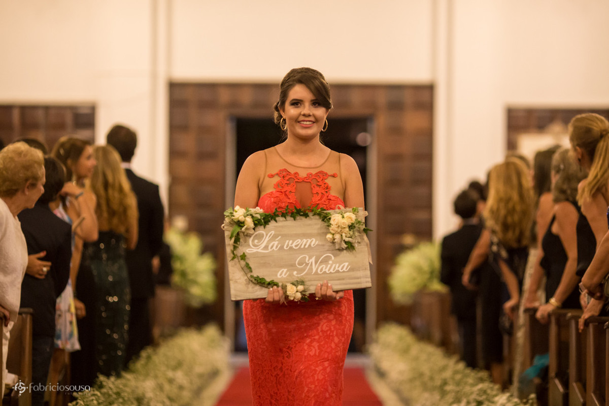 daminha demoseille com a placa "la vem a noiva" no corredor da capela do colégio catarinense