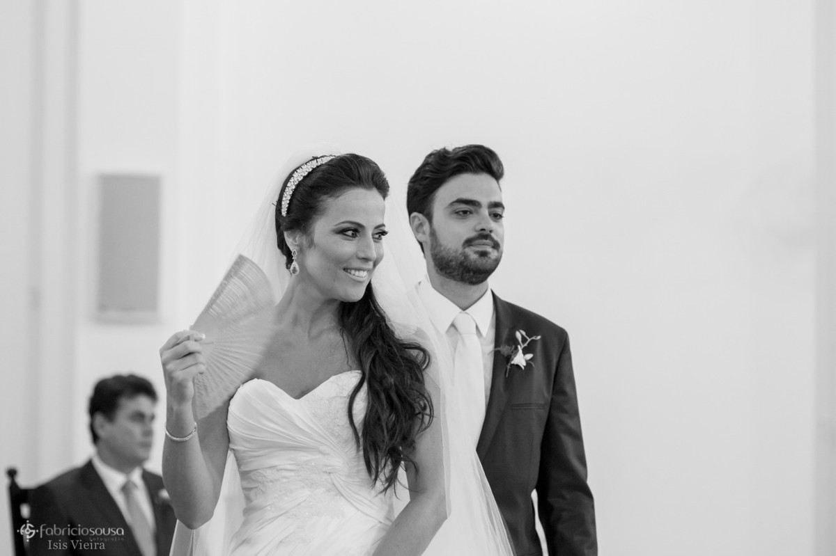 noiva se abanando com leque junto com noivo no altar