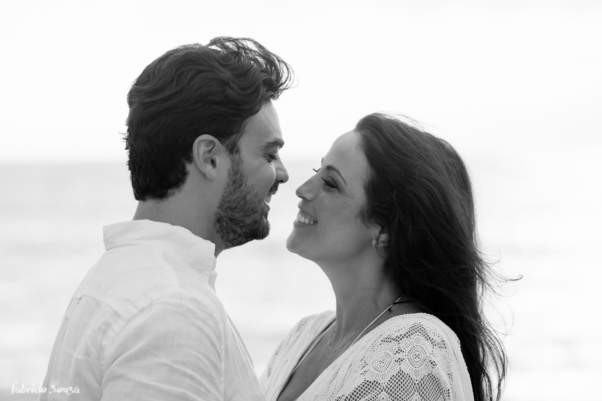 close do casal sorridente em ensaio fotográfico na praia