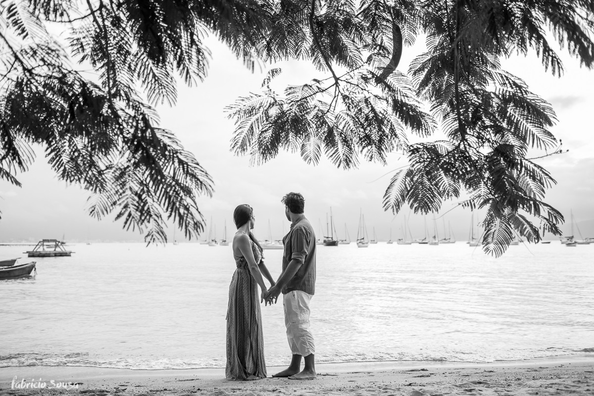 casal de mãos dados sob a arvore na praia de santo antonio de lisboa - final de tarde