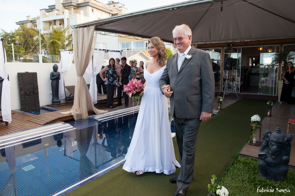a noiva entrando com o pai na borda da piscina