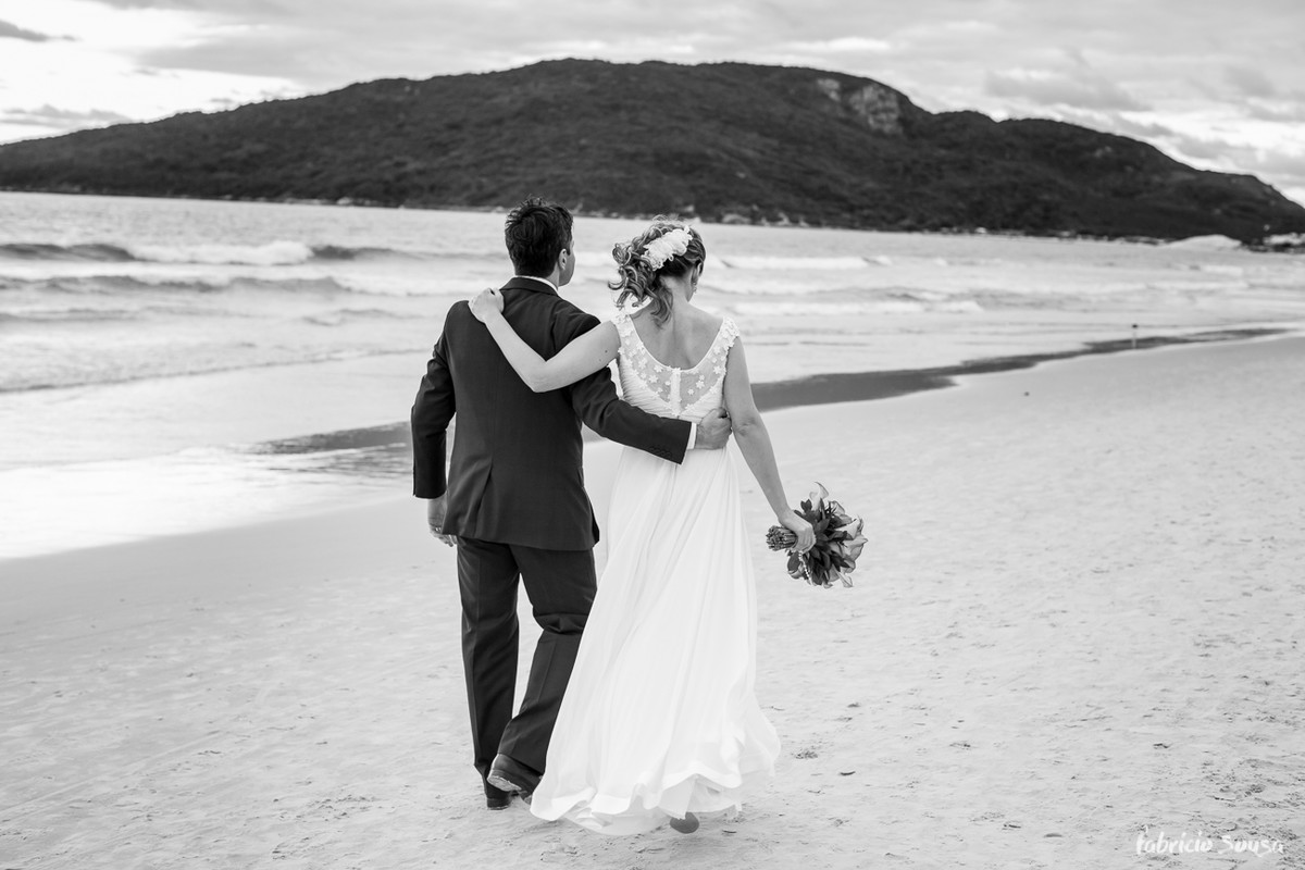 casal de noivos caminhando na praia dos ingleses em Florianópolis
