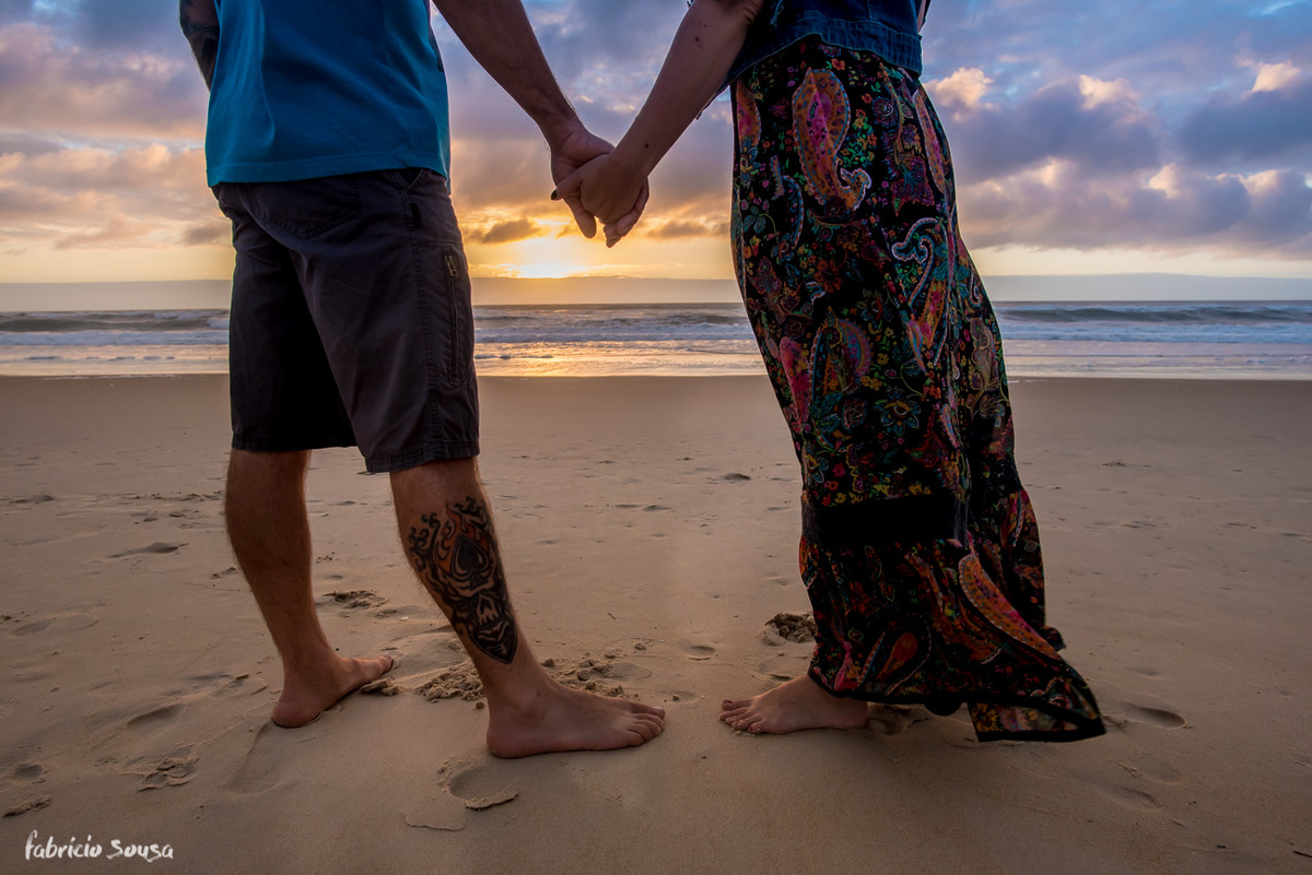 casal de mãos dadas no nascer do sol na praia em Floripa