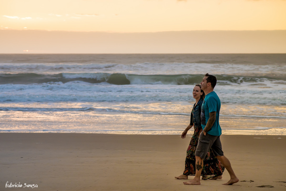 casal caminhando na areia da praia