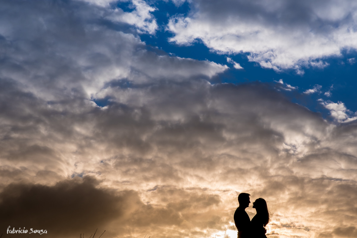 silhueta do casal quase se beijando com céu nebuloso