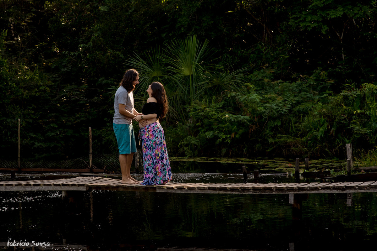silhueta do casal gestante na ponte do balneário