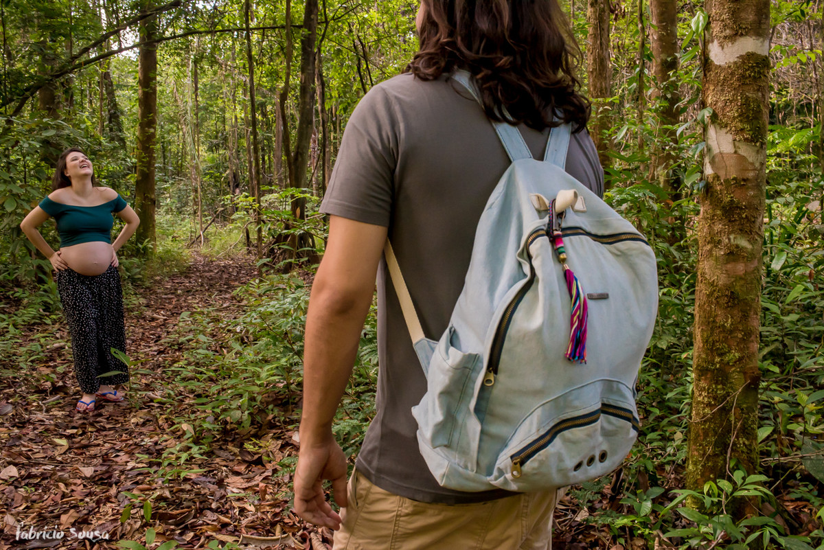 pai de mochila e mãe grávida dando gargalhada