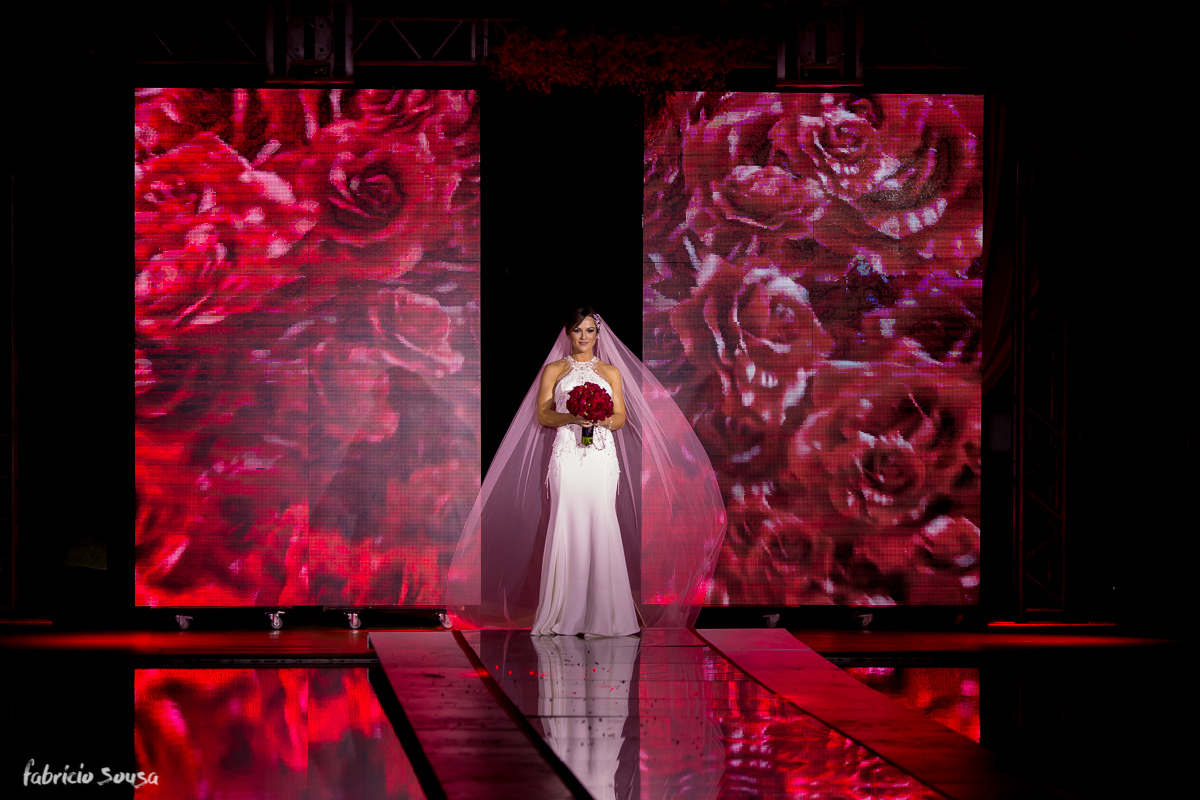 a entrada da noiva através do telão de LED com muitas rosas vermelhas