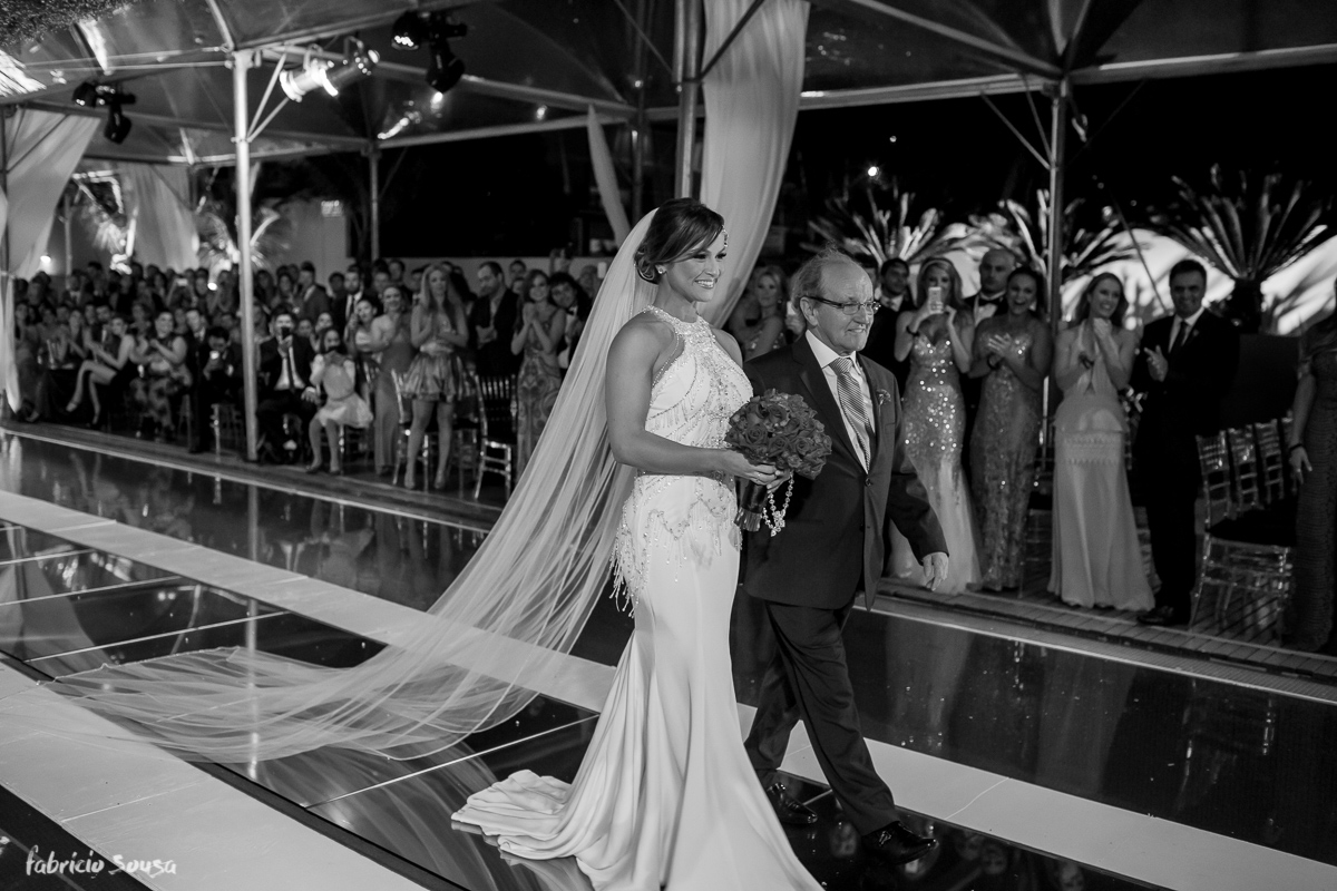 noiva caminha com seu pai para a cerimonia de casamento