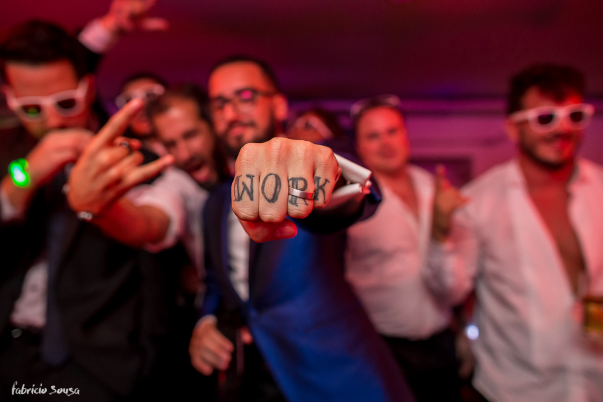 noivo Giu mostra sua mão com tatuagem Work e aliança de casamento