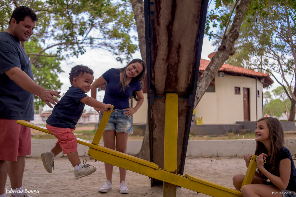 irmãos brincando na gangorra na sessão fotográfica de família