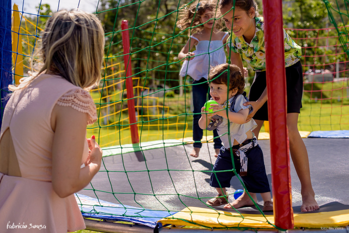 aniversariante brincando no pula-pula sorri para mamãe