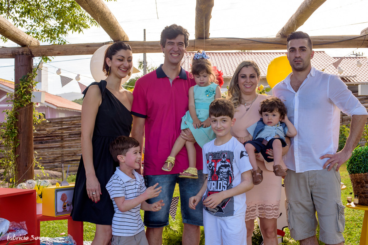 família posa para retrato na festa infantil em frente ao bolo