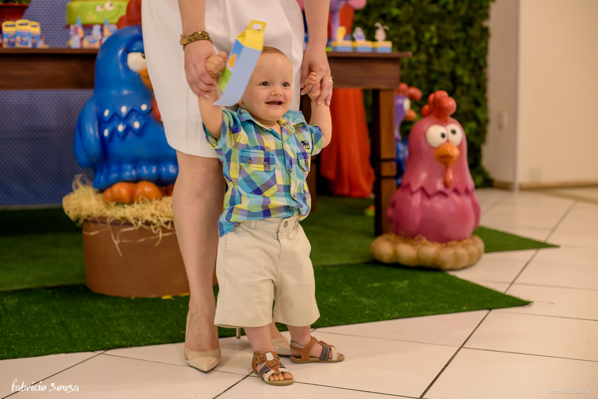 bebe dando os primeiros passos com ajuda da mamãe no aniversário infantil