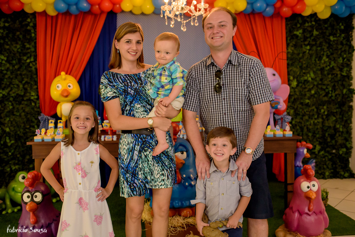 retrato do aniversariante com padrinhos em frente a decoracao de galinha pintadinha