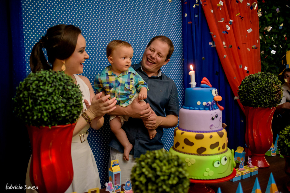 pais muito felizes cantando parabéns no primeiro aniversário infantil do filho