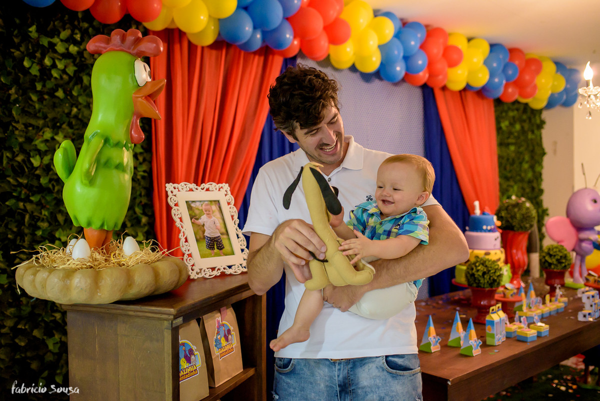 Henrique bebe sorridente brincando com titio Leandro