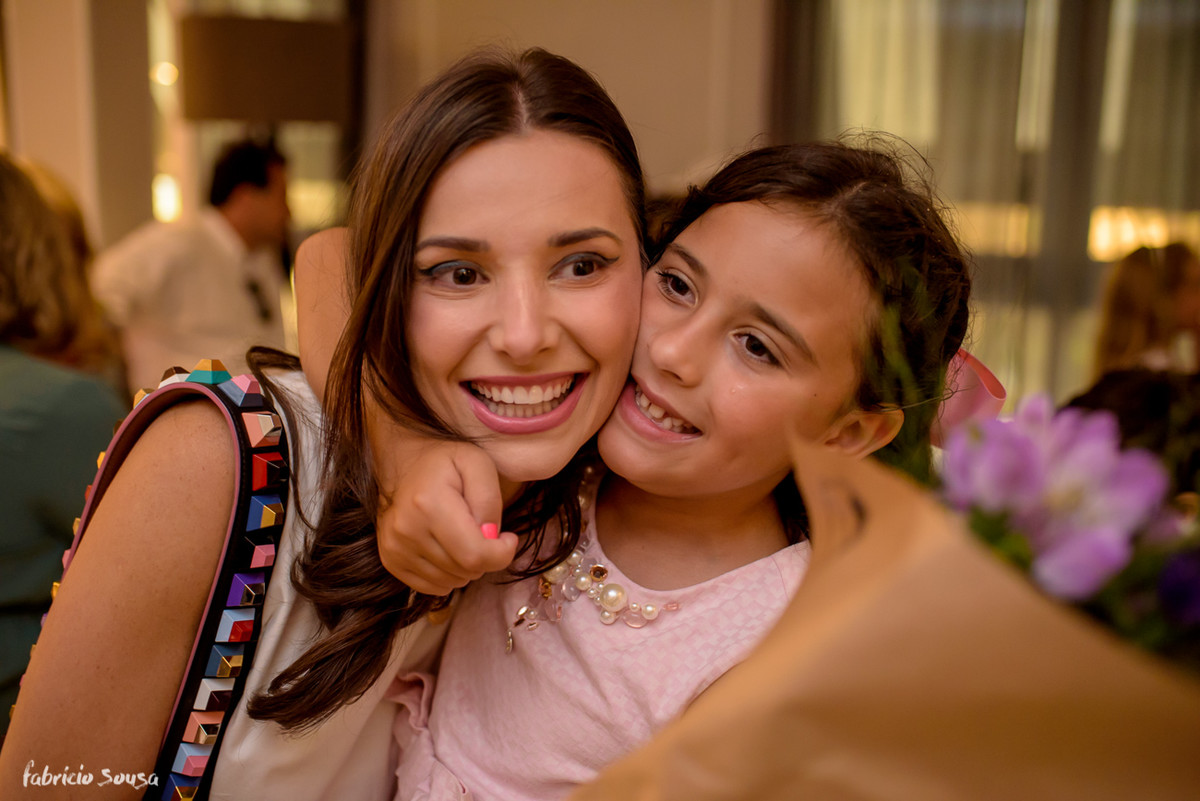aniversariante abraça tia após receber buquet de flores de presente