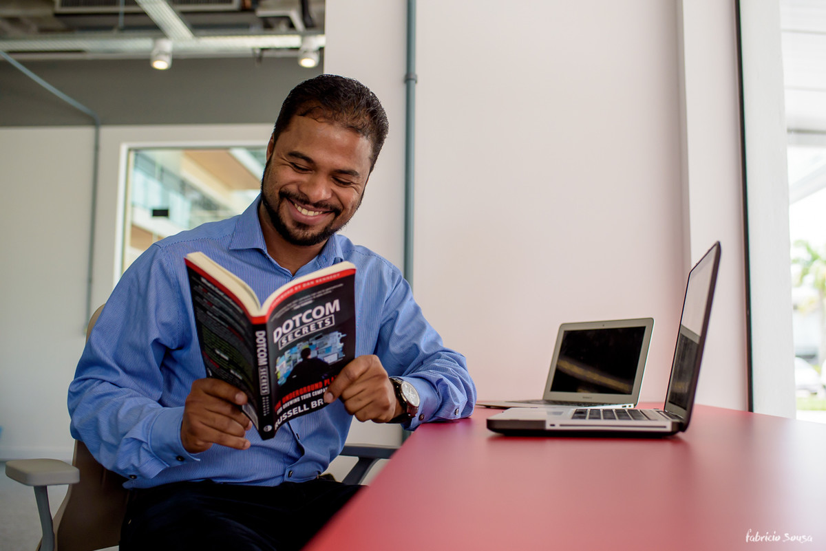 empreendedor lendo seu livro dotcom secrets no ambiente de trabalho