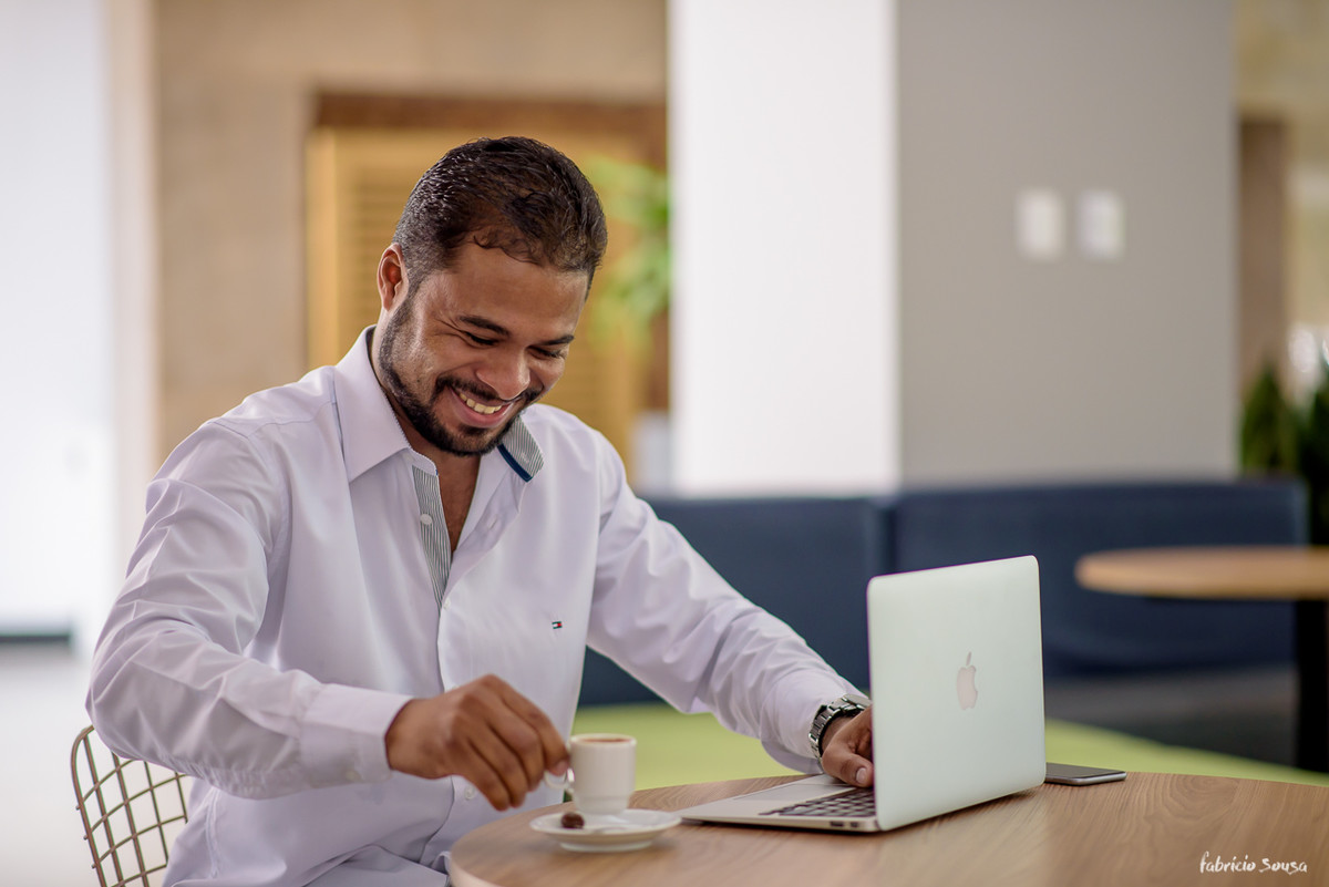 especialista em vendas online Daniel Dias tomando um café e sorrindo no intervalo do trabalho