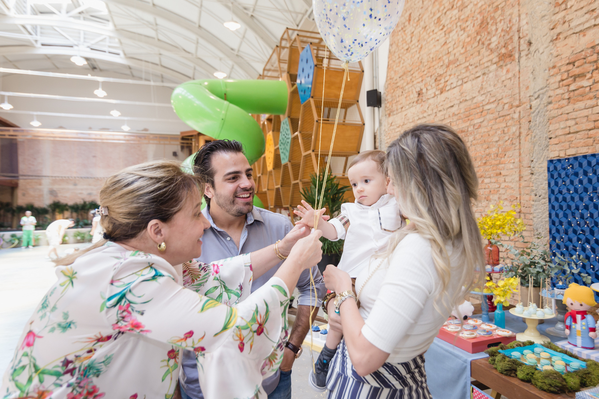 criança segurando balões