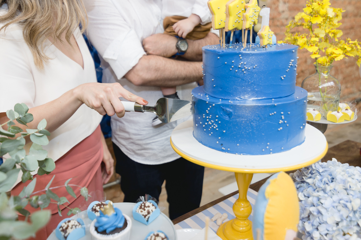 mãe cortando o bolo de aniversário do filho