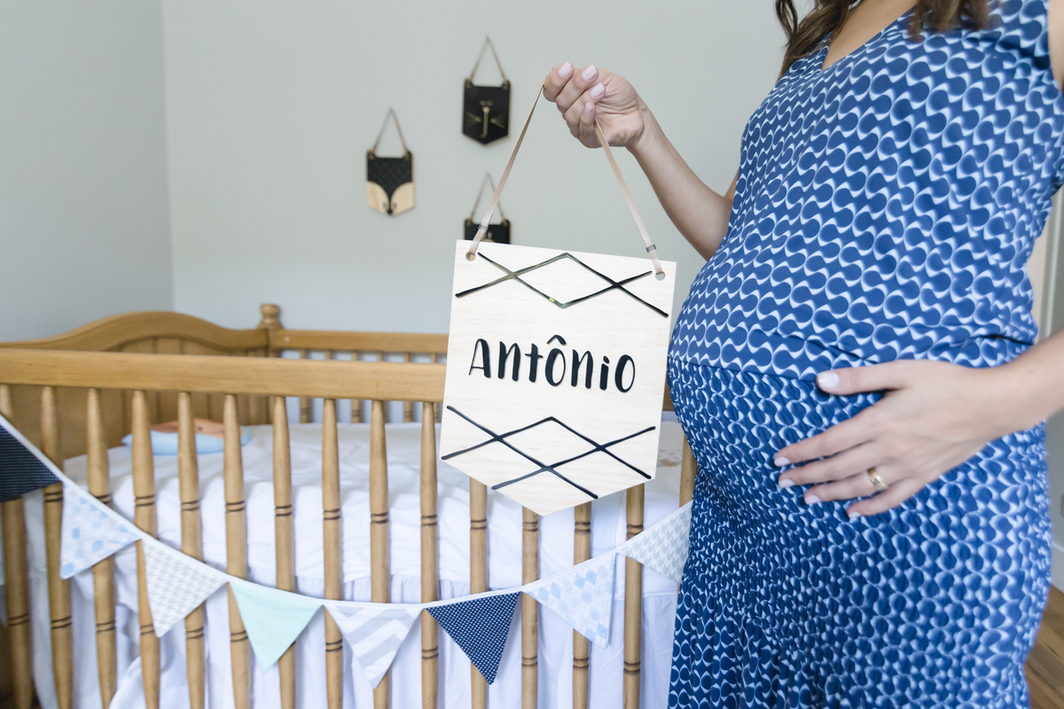 Mãe segurando flamula de madeira com o nome do filho escrito