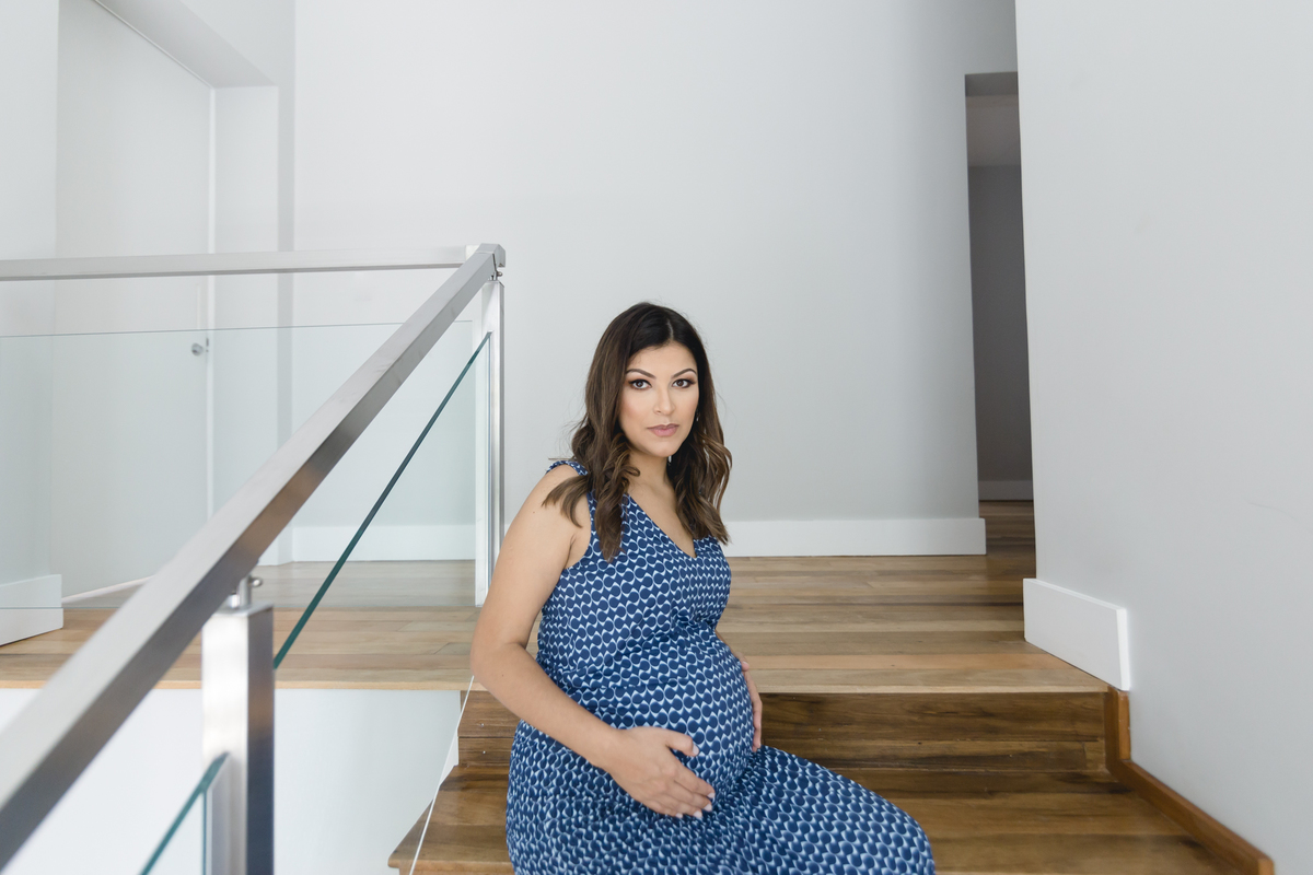 Mulher grávida sentada na escada de casa