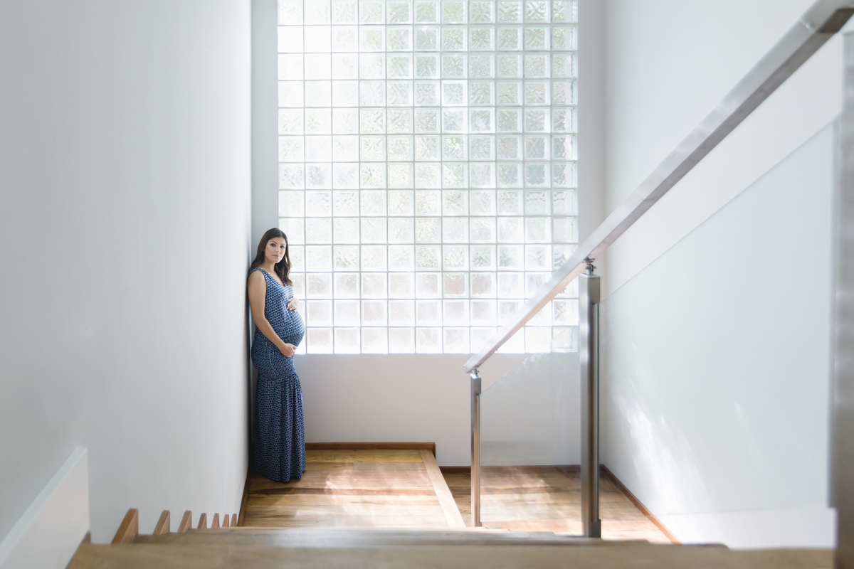 Mulher grávida na escada de casa