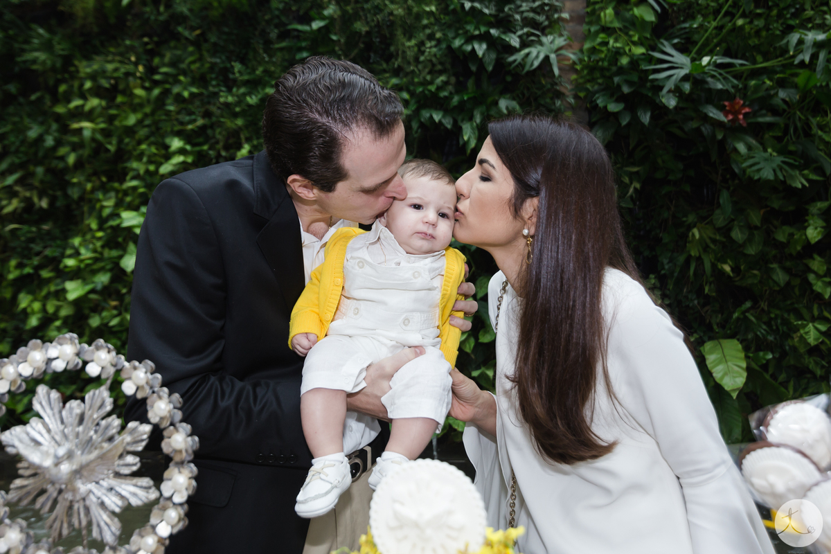 pai e mae beijando filho no rosto