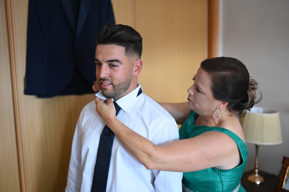 mae do noite colocando gravata