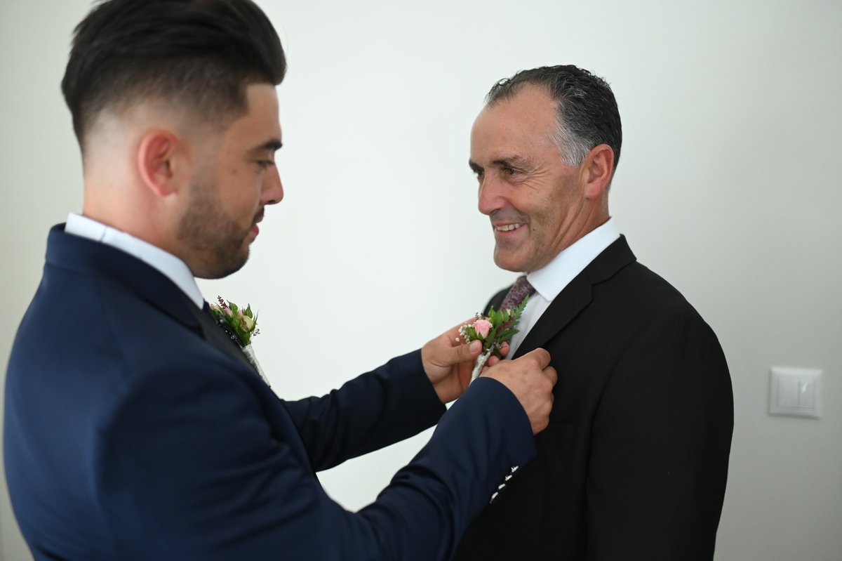 noivo colocando flor no padrinho