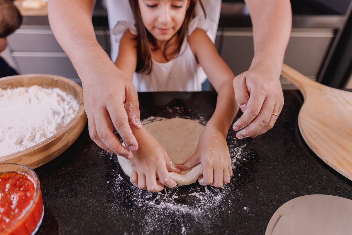 ensaio familia em casa camisa branca e calça jeans 2 filhos fazendo pizza