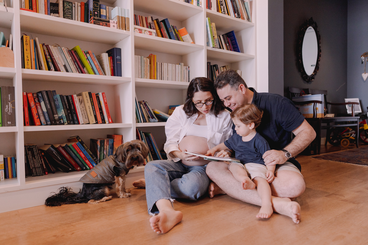 ensaio gestante em casa segundo filho prateleira cheia de livros 