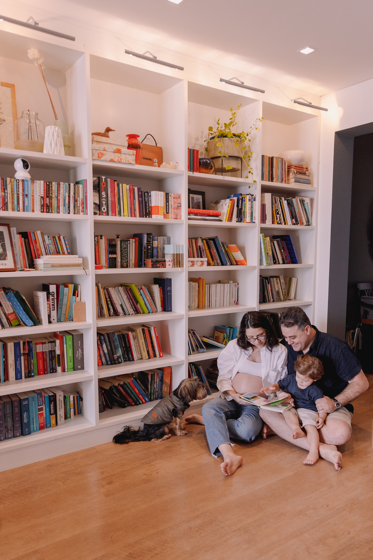 ensaio gestante em casa segundo filho prateleira cheia de livros 
