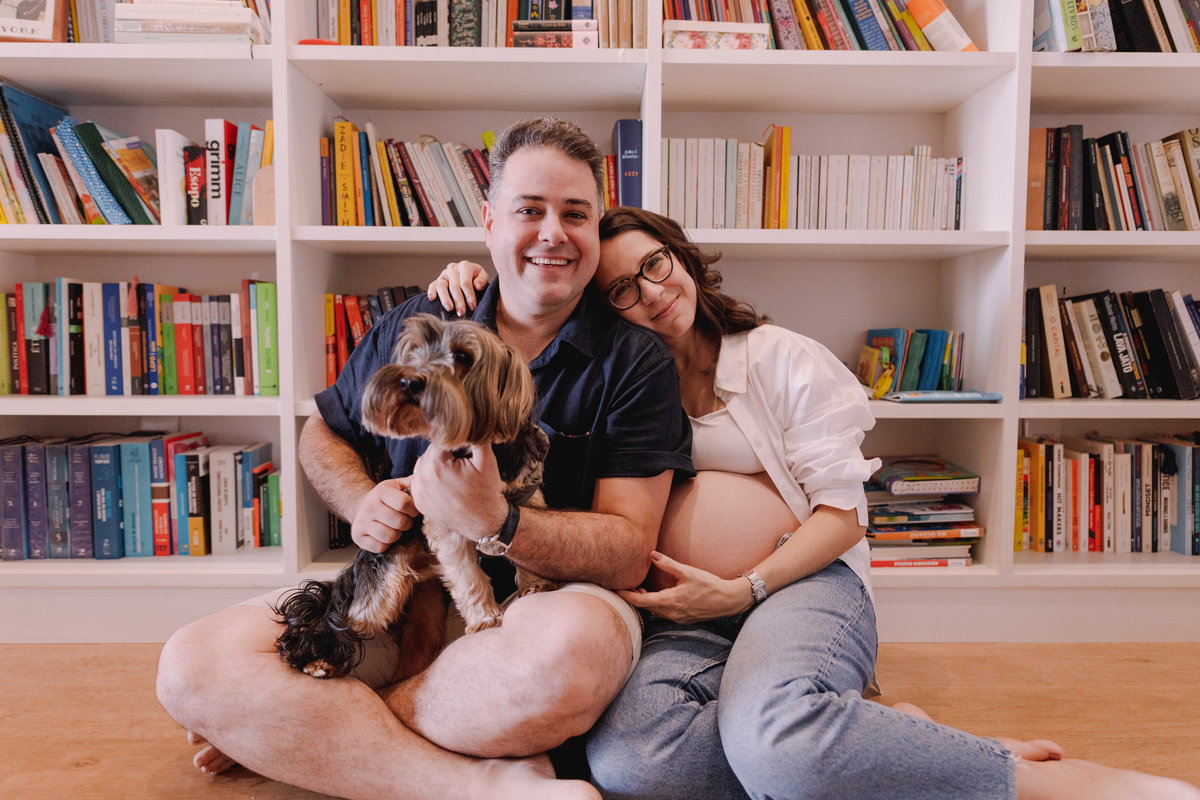 ensaio gestante em casa segundo filho prateleira cheia de livros 