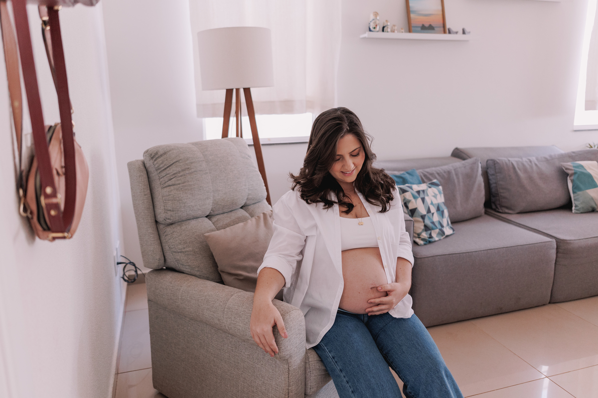 ensaio gestante em casa com pet calça jeans e camisa branca