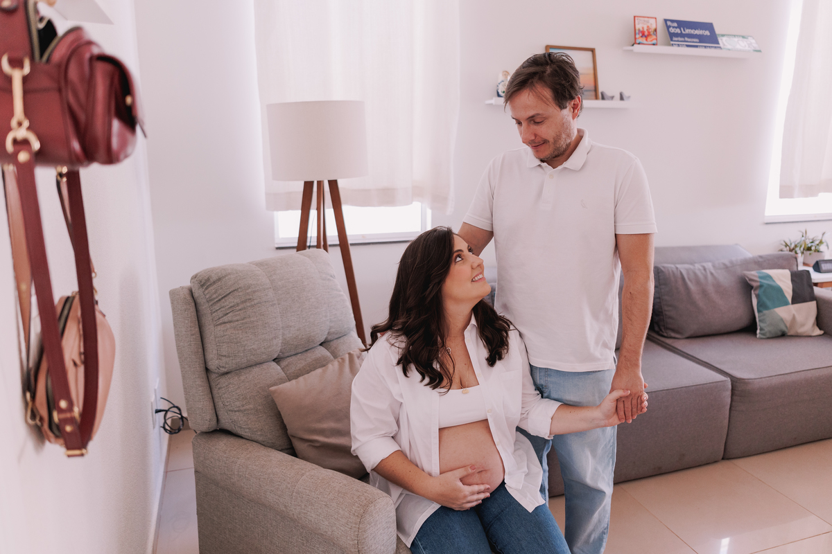 ensaio gestante em casa com pet calça jeans e camisa branca